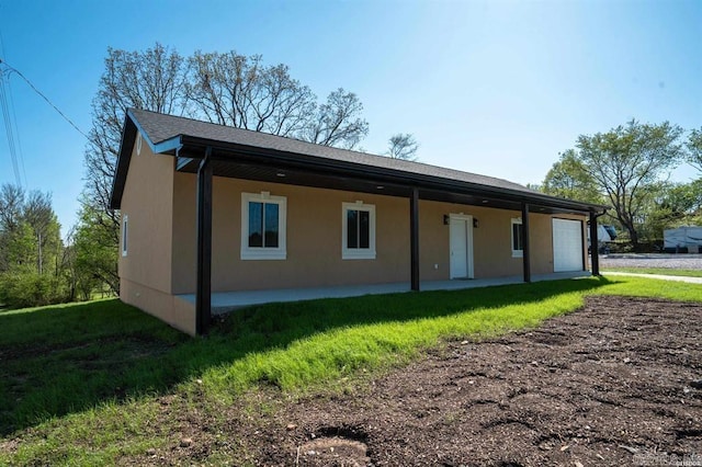 back of house featuring a yard, a patio, and stucco siding