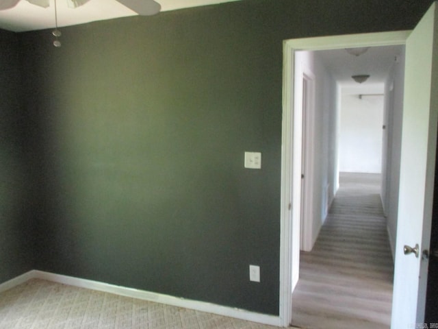 empty room with ceiling fan and baseboards