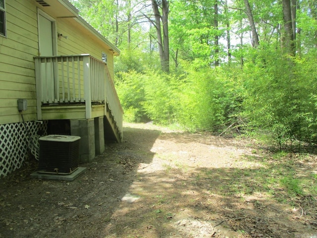 view of yard featuring cooling unit and a deck