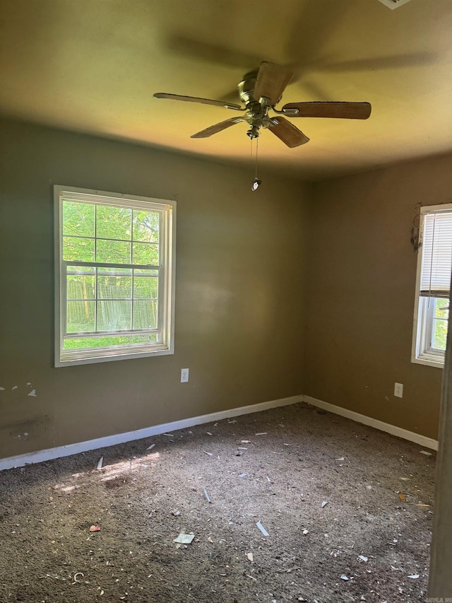 spare room with baseboards and ceiling fan