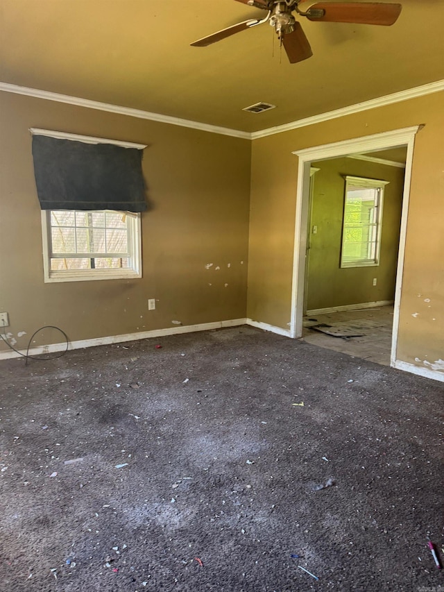 unfurnished room with baseboards, visible vents, ceiling fan, and crown molding