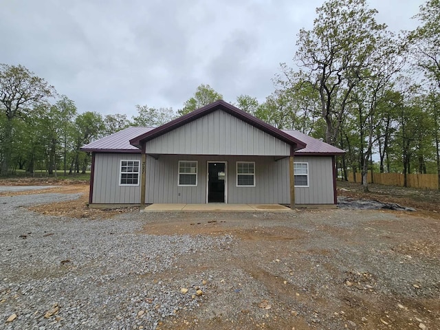 view of front of property featuring fence, a porch, and metal roof