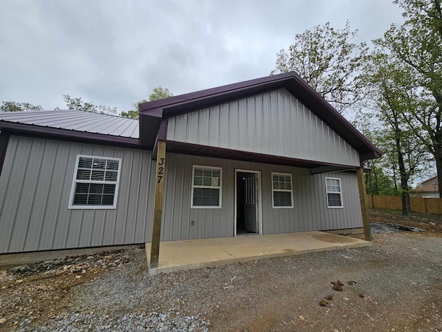 view of front of property with fence and metal roof