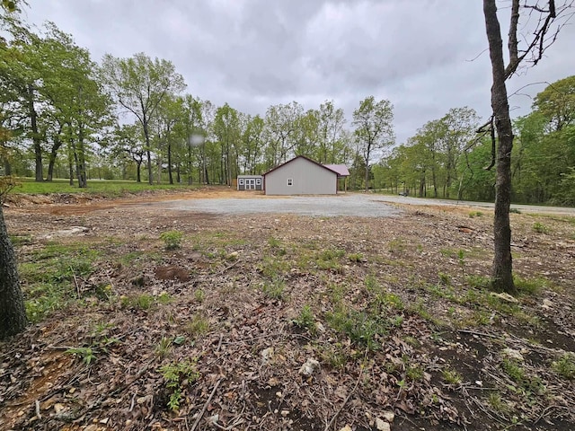 view of yard with a pole building and a forest view