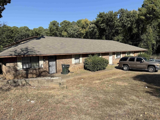 ranch-style house featuring brick siding and a front yard