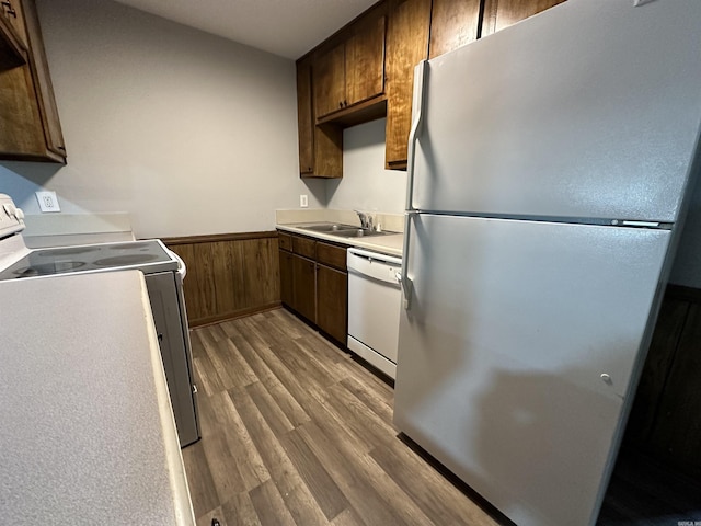 kitchen featuring wood finished floors, dishwasher, a wainscoted wall, range, and freestanding refrigerator