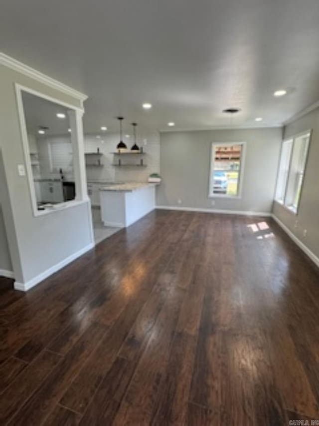 unfurnished living room with recessed lighting, crown molding, baseboards, and dark wood-style flooring