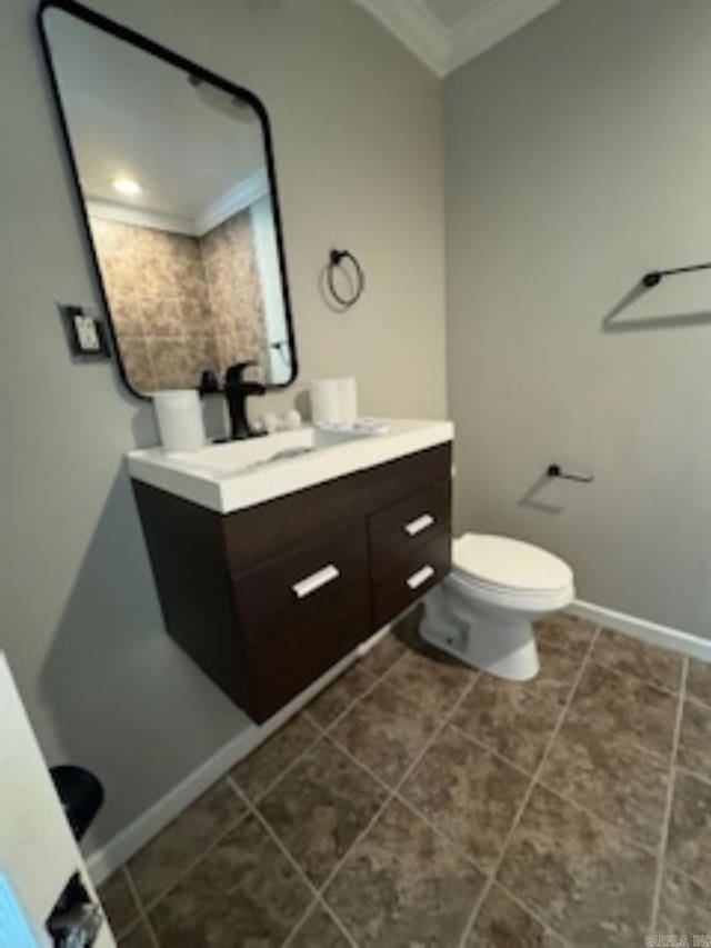 bathroom featuring crown molding, vanity, baseboards, toilet, and tile patterned flooring