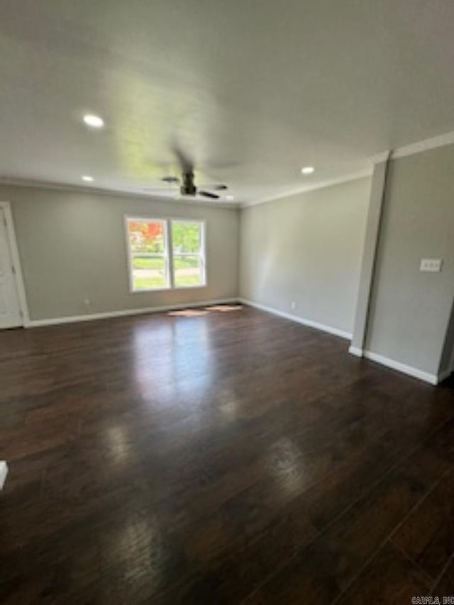 unfurnished room with dark wood finished floors, crown molding, and a ceiling fan