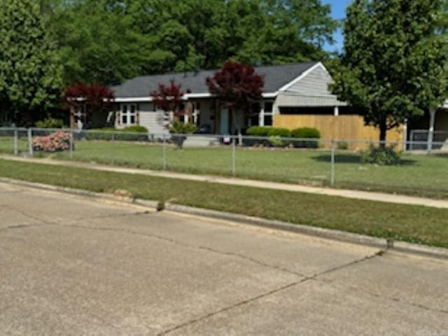 ranch-style home featuring a front lawn and a fenced front yard