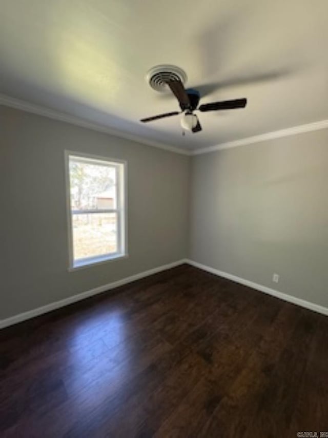 spare room with baseboards, dark wood-type flooring, and crown molding