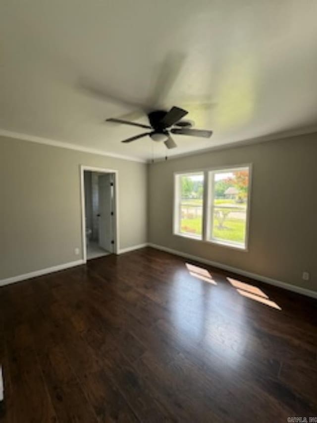 unfurnished room with ornamental molding, baseboards, a ceiling fan, and dark wood-style floors