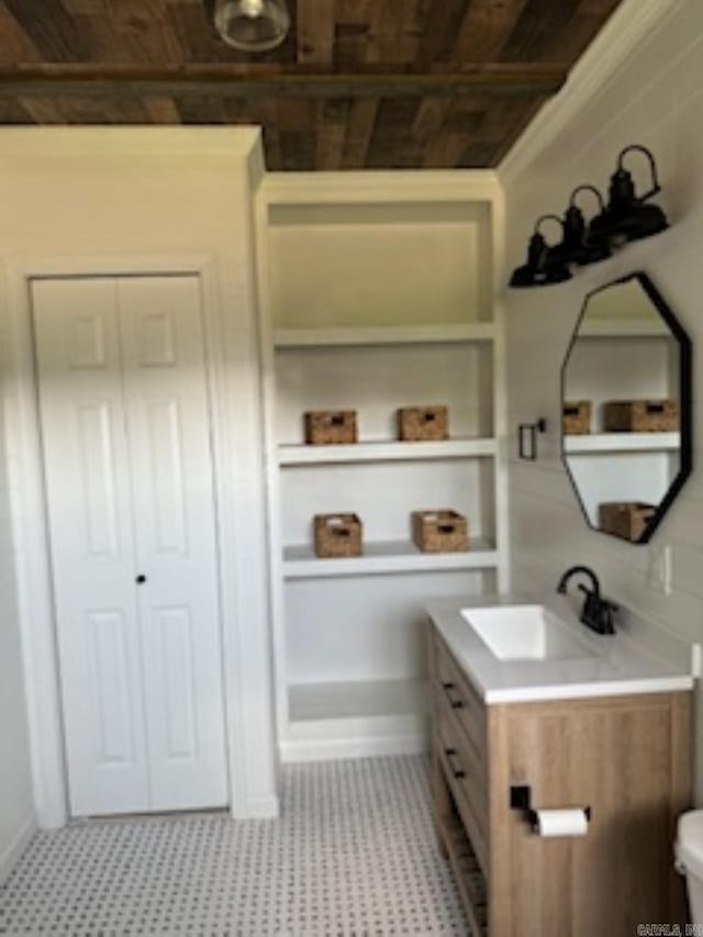 bathroom featuring toilet, vanity, and baseboards