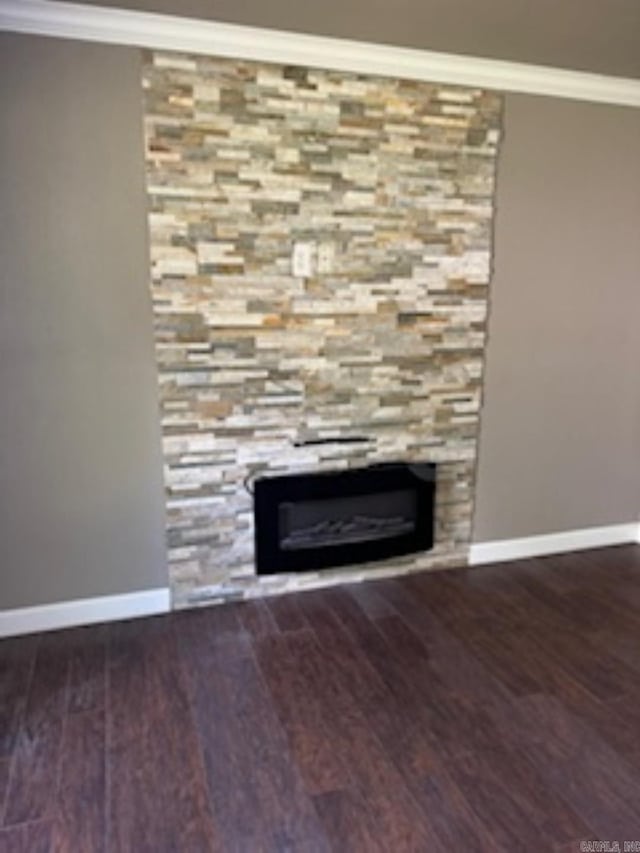 room details featuring wood finished floors, baseboards, a fireplace, and crown molding