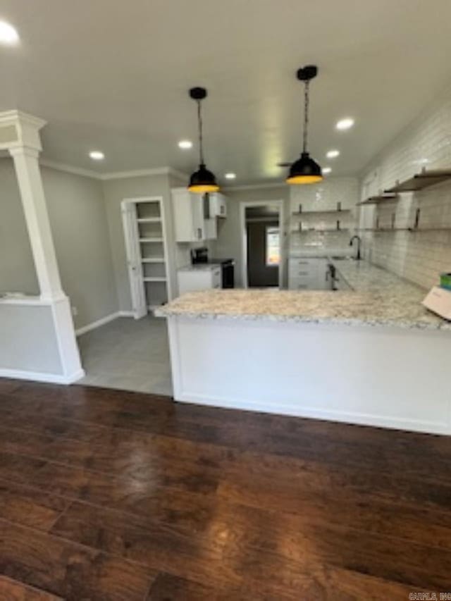 kitchen with light stone countertops, a peninsula, pendant lighting, and recessed lighting