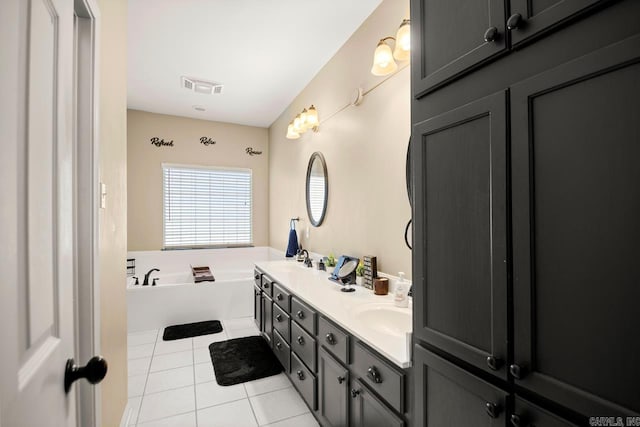 bathroom with a sink, visible vents, tile patterned flooring, double vanity, and a garden tub
