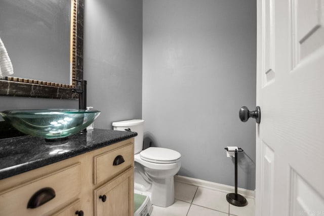 bathroom with toilet, tile patterned flooring, vanity, and baseboards