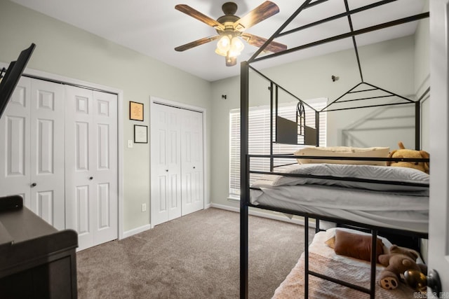 unfurnished bedroom featuring a ceiling fan, carpet floors, baseboards, and multiple closets