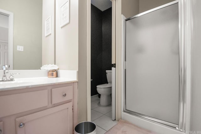 bathroom featuring a stall shower, tile patterned flooring, vanity, and toilet