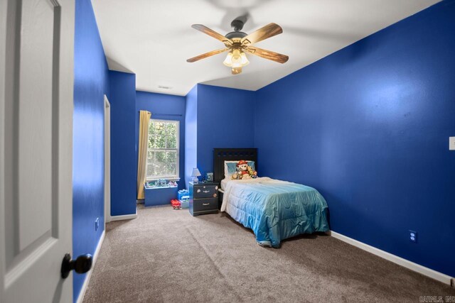 carpeted bedroom featuring baseboards and a ceiling fan