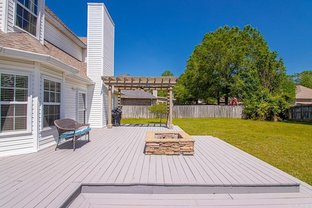 wooden deck featuring a pergola, a fenced backyard, a fire pit, and a lawn