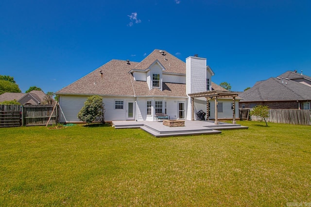 back of property featuring a yard, a deck, a pergola, and a fenced backyard
