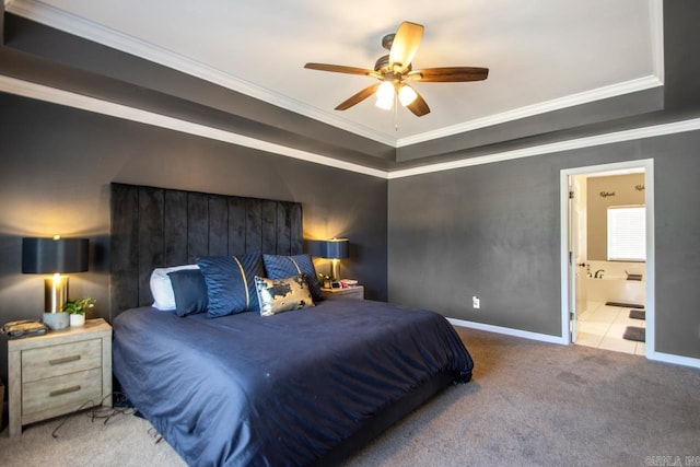 bedroom with carpet, a tray ceiling, crown molding, ensuite bathroom, and baseboards