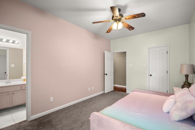 bedroom with a ceiling fan, a sink, carpet floors, baseboards, and ensuite bath