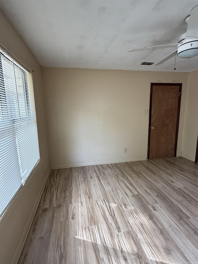 spare room with baseboards, visible vents, and light wood-type flooring