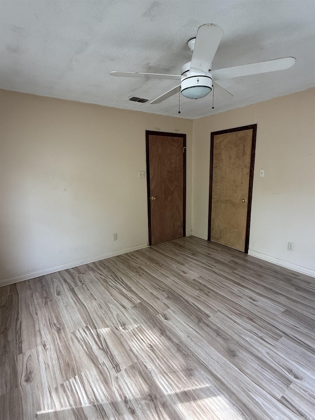 unfurnished bedroom with light wood-type flooring, baseboards, and ceiling fan