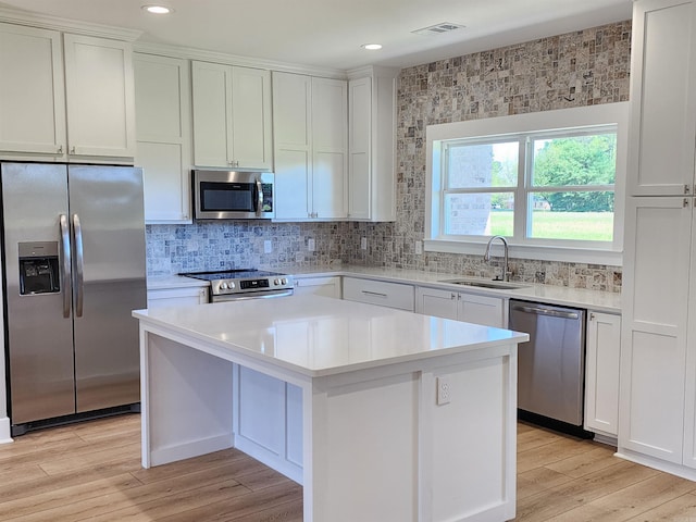 290 Walker St, Higginson, AR 72068 - kitchen featuring light wood finished floors, stainless steel appliances, light countertops, a sink, and a kitchen island