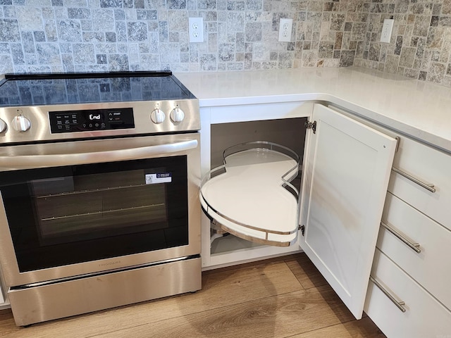 290 Walker St, Higginson, AR 72068 - room details featuring white cabinets, tasteful backsplash, wood finished floors, light countertops, and electric stove