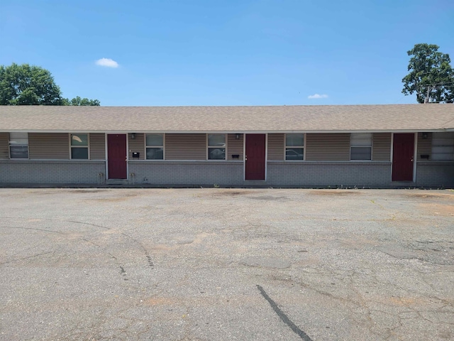 ranch-style house with uncovered parking and brick siding