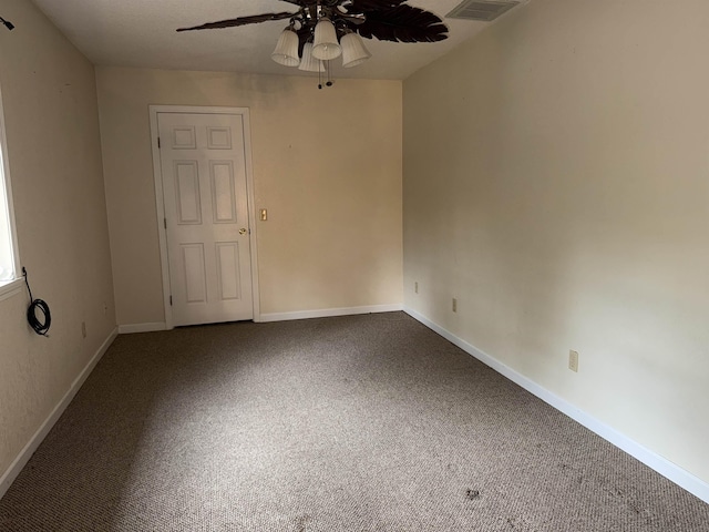 unfurnished room featuring carpet floors, visible vents, baseboards, and ceiling fan