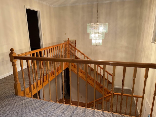 staircase featuring baseboards, carpet flooring, a notable chandelier, and crown molding