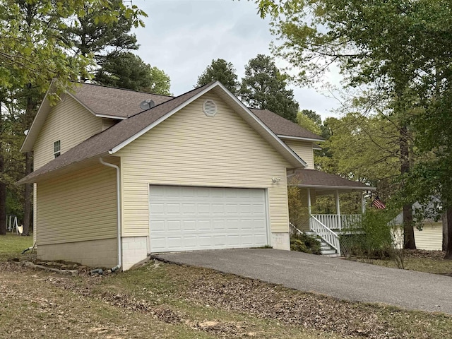 view of front facade with an attached garage, driveway, a porch, and a shingled roof