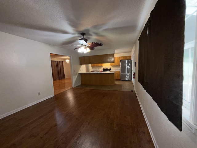 unfurnished living room featuring baseboards, a textured ceiling, ceiling fan, and dark wood finished floors