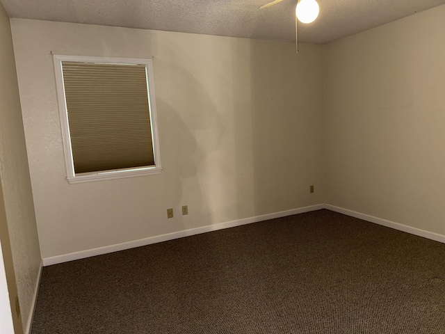 unfurnished room featuring dark colored carpet, baseboards, a textured ceiling, and ceiling fan