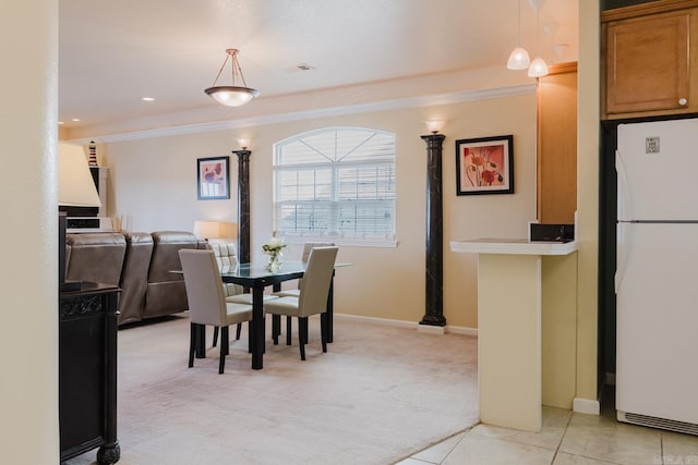 dining room featuring crown molding, light colored carpet, baseboards, visible vents, and decorative columns