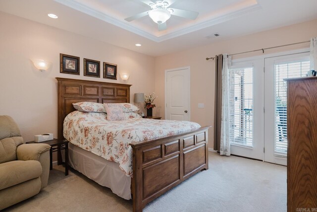 bedroom featuring a tray ceiling, visible vents, light colored carpet, and access to exterior