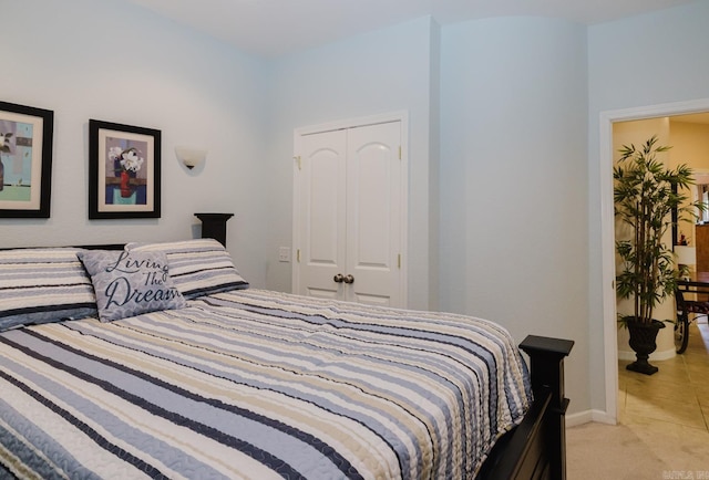 bedroom featuring a closet, baseboards, and light carpet