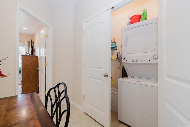 laundry room with stacked washer and clothes dryer, laundry area, and light tile patterned flooring