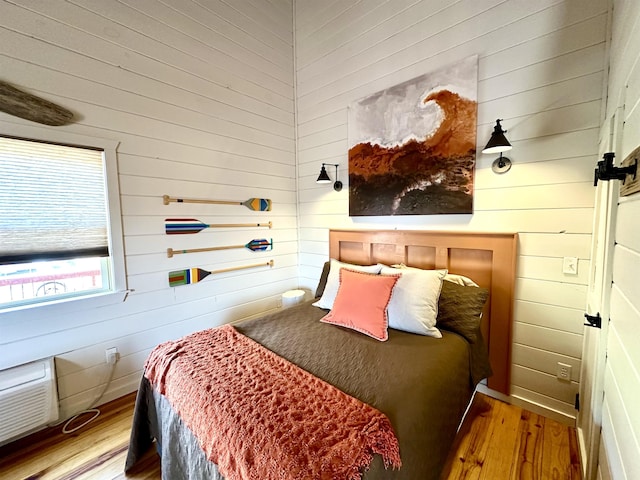 bedroom with wooden walls and wood finished floors