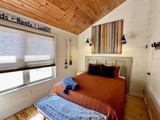 bedroom featuring vaulted ceiling, wood walls, wood ceiling, and wood finished floors