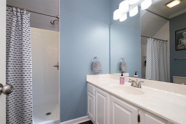 bathroom featuring a tile shower, vanity, and ornamental molding