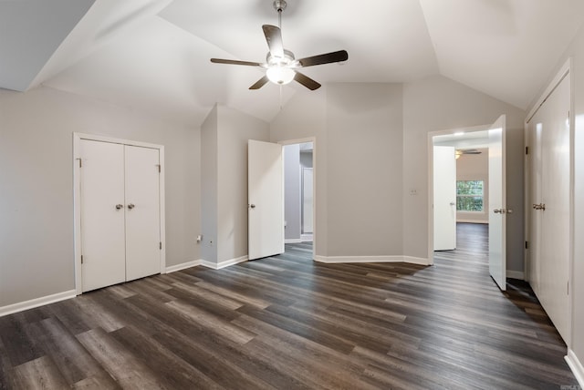 unfurnished bedroom with vaulted ceiling, baseboards, dark wood-type flooring, and a ceiling fan