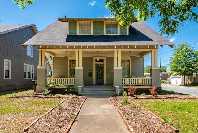 bungalow-style home with a shingled roof, ceiling fan, and covered porch