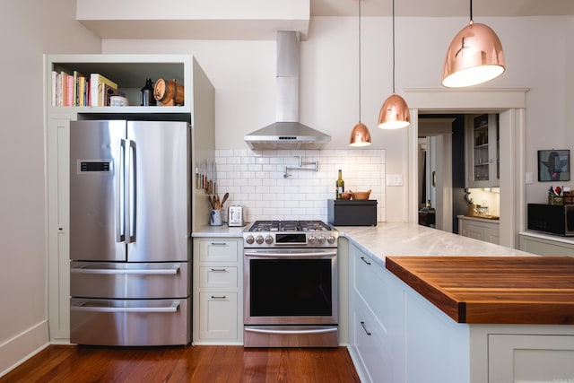 kitchen with dark wood-type flooring, wall chimney exhaust hood, decorative backsplash, wood counters, and appliances with stainless steel finishes