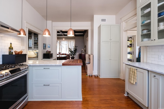 kitchen with wood finished floors, glass insert cabinets, stainless steel gas range, pendant lighting, and tasteful backsplash