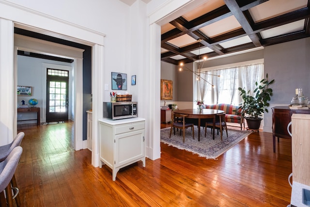 dining space with hardwood / wood-style flooring, beam ceiling, and coffered ceiling